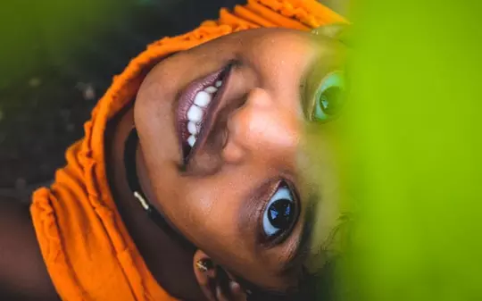 Little Indian girl smiling towards the camera in orange clothes