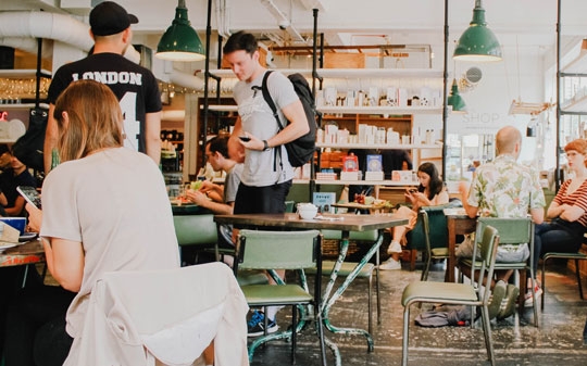 People eating in cafeteria and chatting