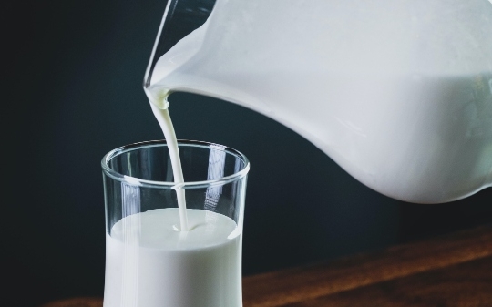 Milk jug pouring in a glass