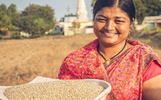 Smiling woman holding ground millet