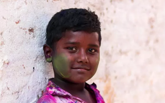 Young boy in Pakistan wearing a colorful shirt and smiling